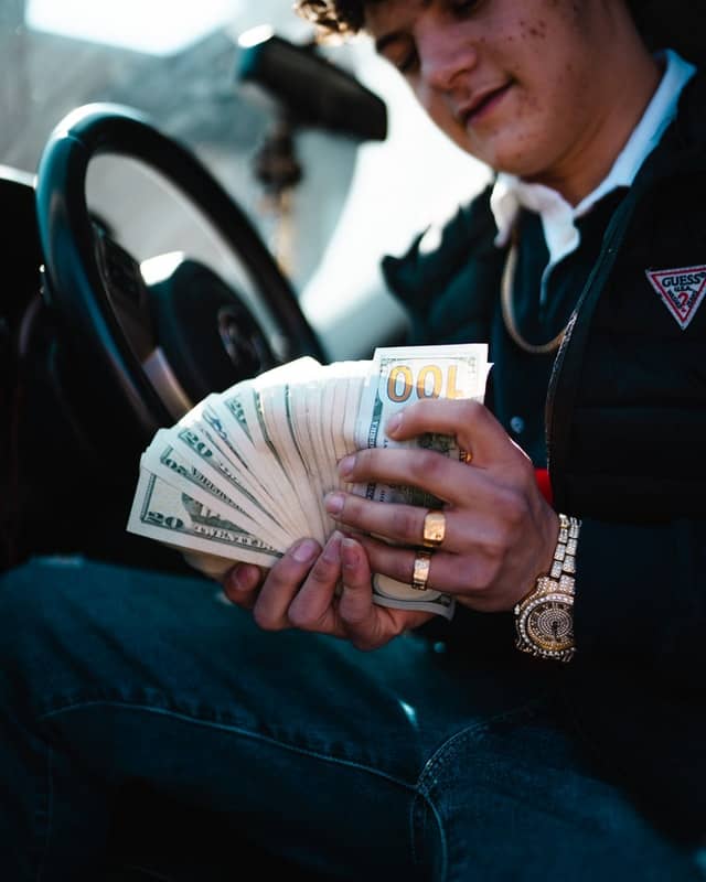 A man holding many dollars